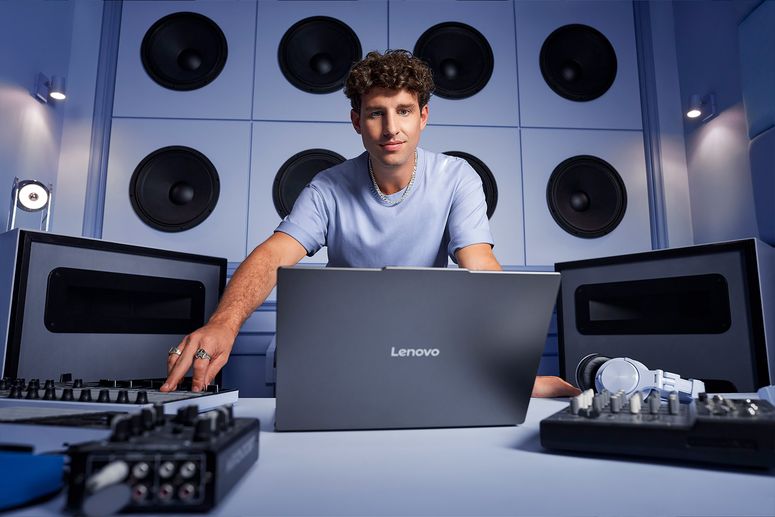 hombre joven en un estudio de grabación con una laptop lenovo