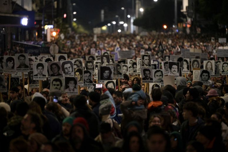 Varias personas sostienen retratos de los desaparecidos durante la última dictadura en Uruguay durante la Marcha del Silencio en Montevideo el 20 de mayo de 2024.