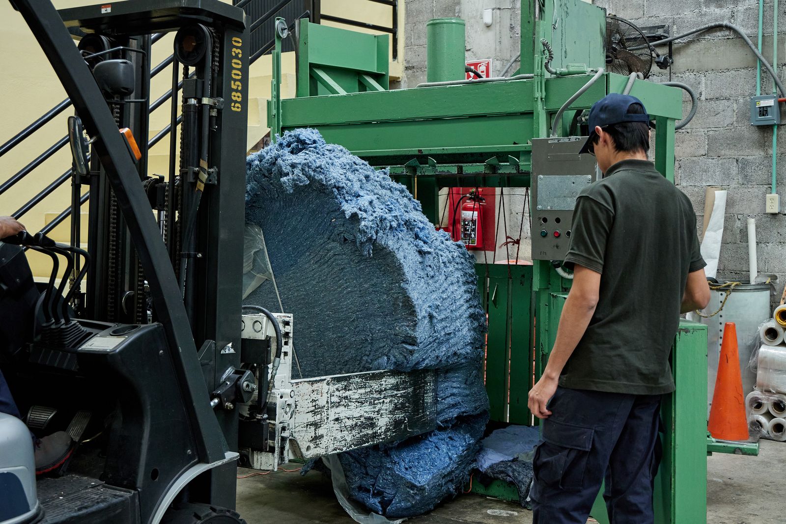 hombre manejando mquina para reciclar mezclilla